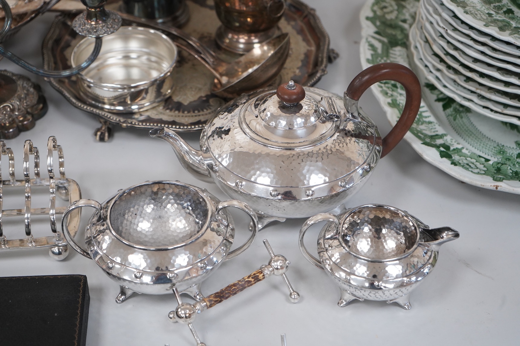 A collection of silver plate to include cased dessert forks, a hammered tea pot, pair of candlesticks and a salver